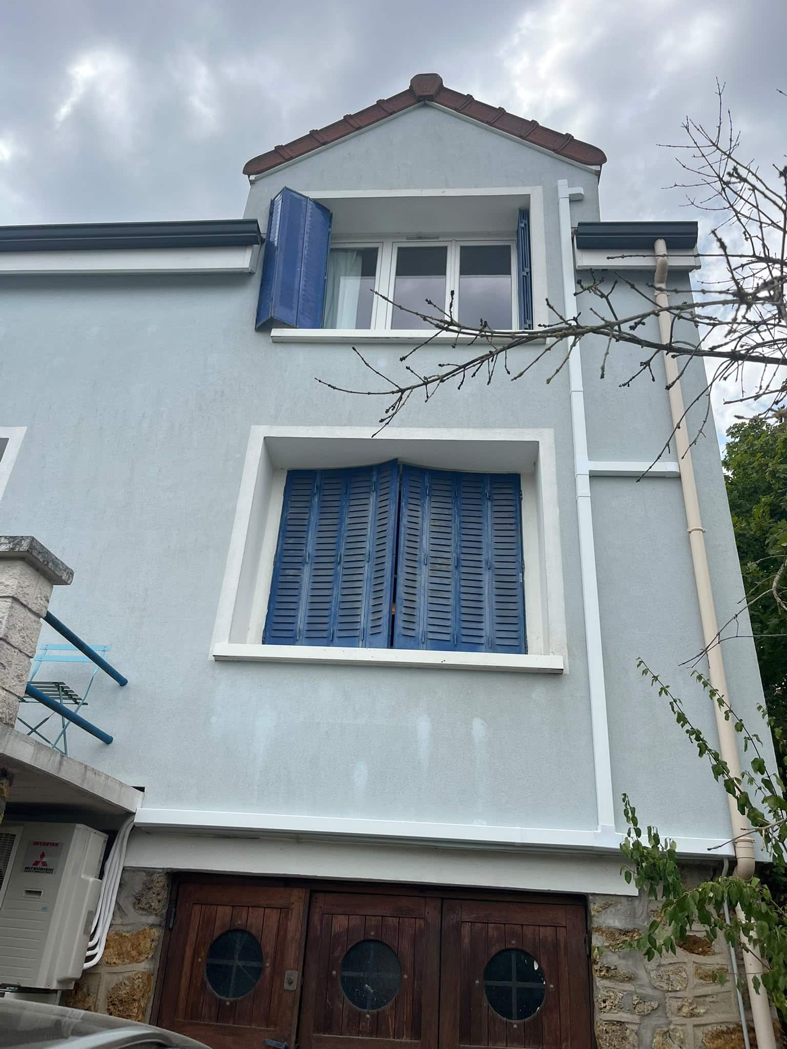 Façade ravalée — pavillon avec volets bleus